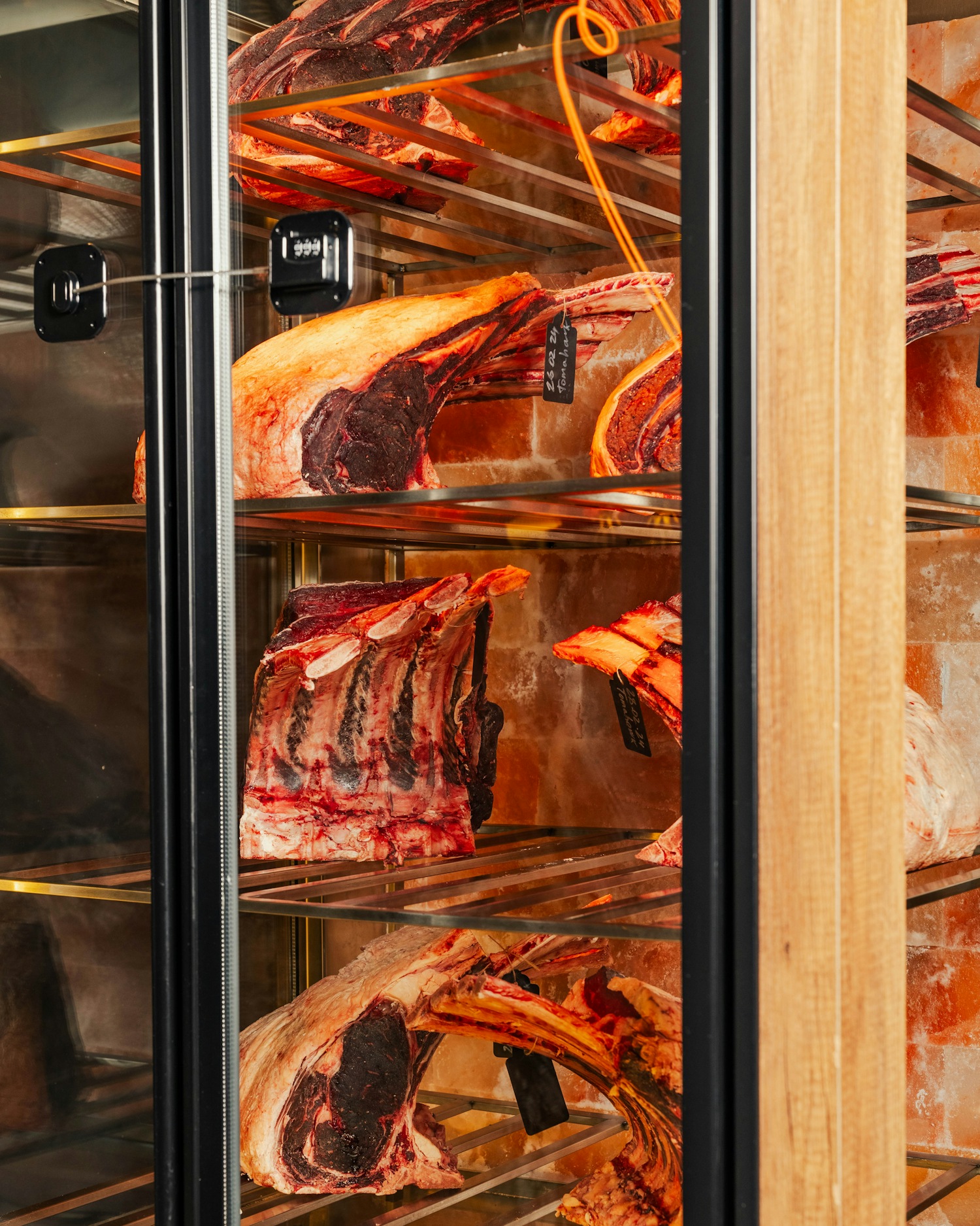 Himalayan salt dry-aging cabinet full of tomahawk steaks