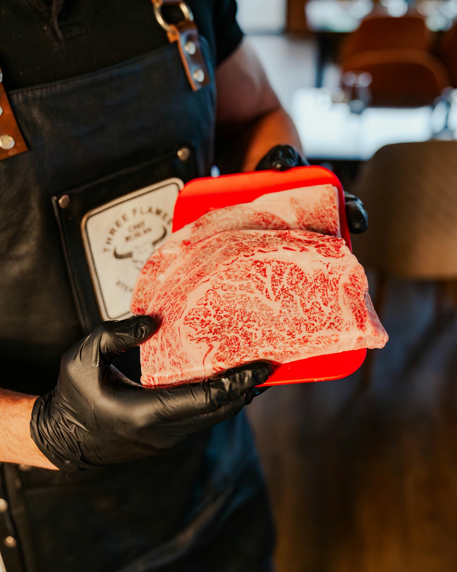 Butcher holding a heavily marbled A5 Wagyu striploin