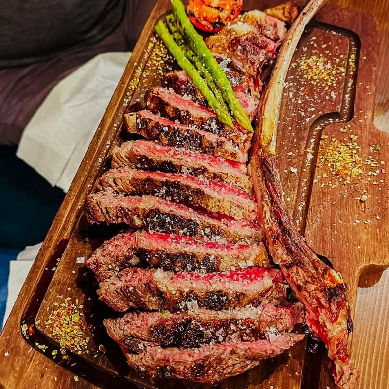 The tomahawk steak, carved at your table