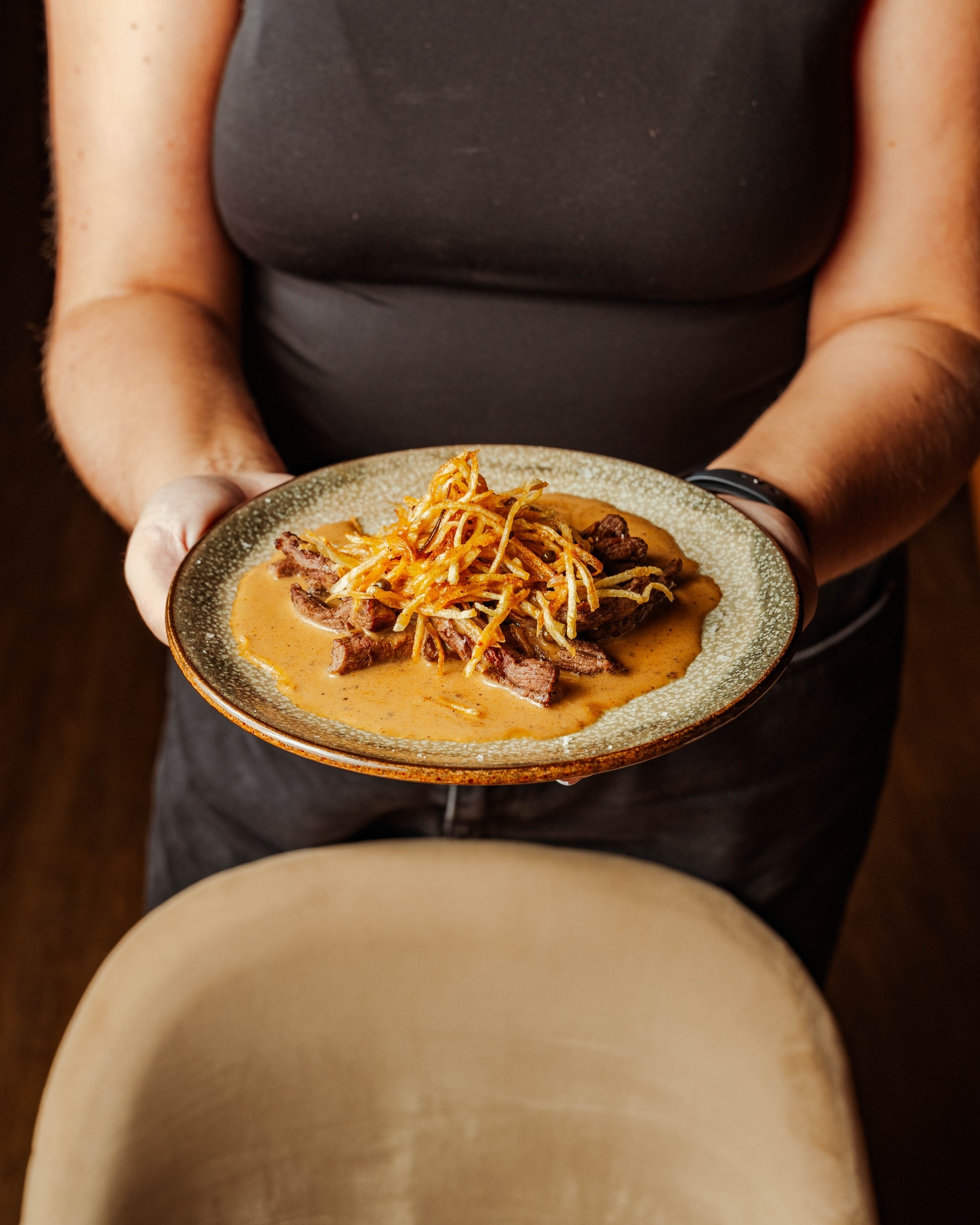 Steak in peppercorn sauce topped with crisp shoestring fries