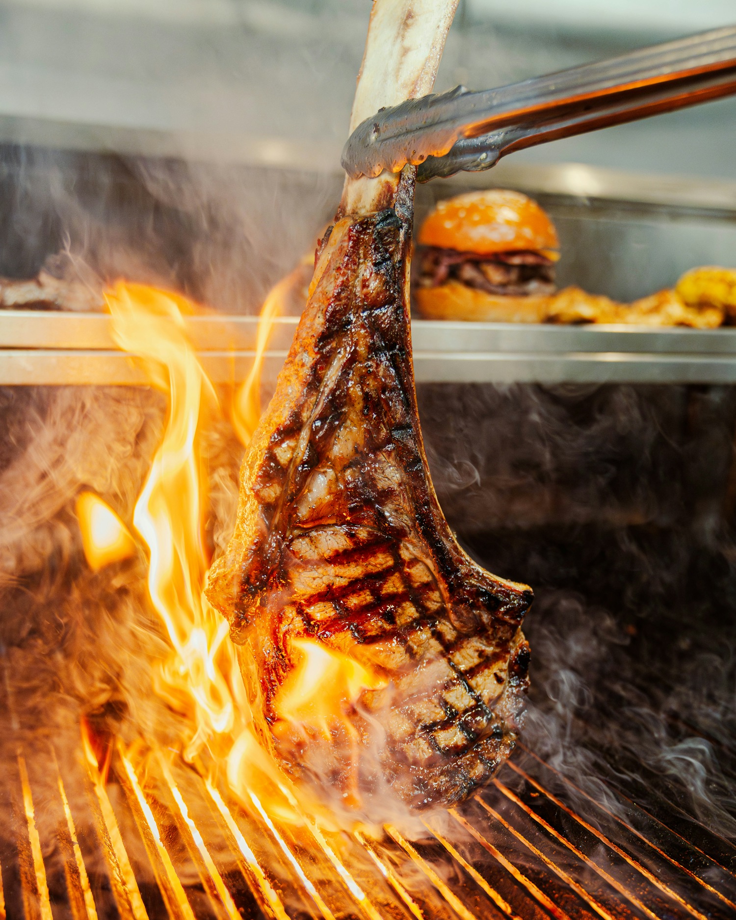 Tomahawk steak flaming on the charcoal grill