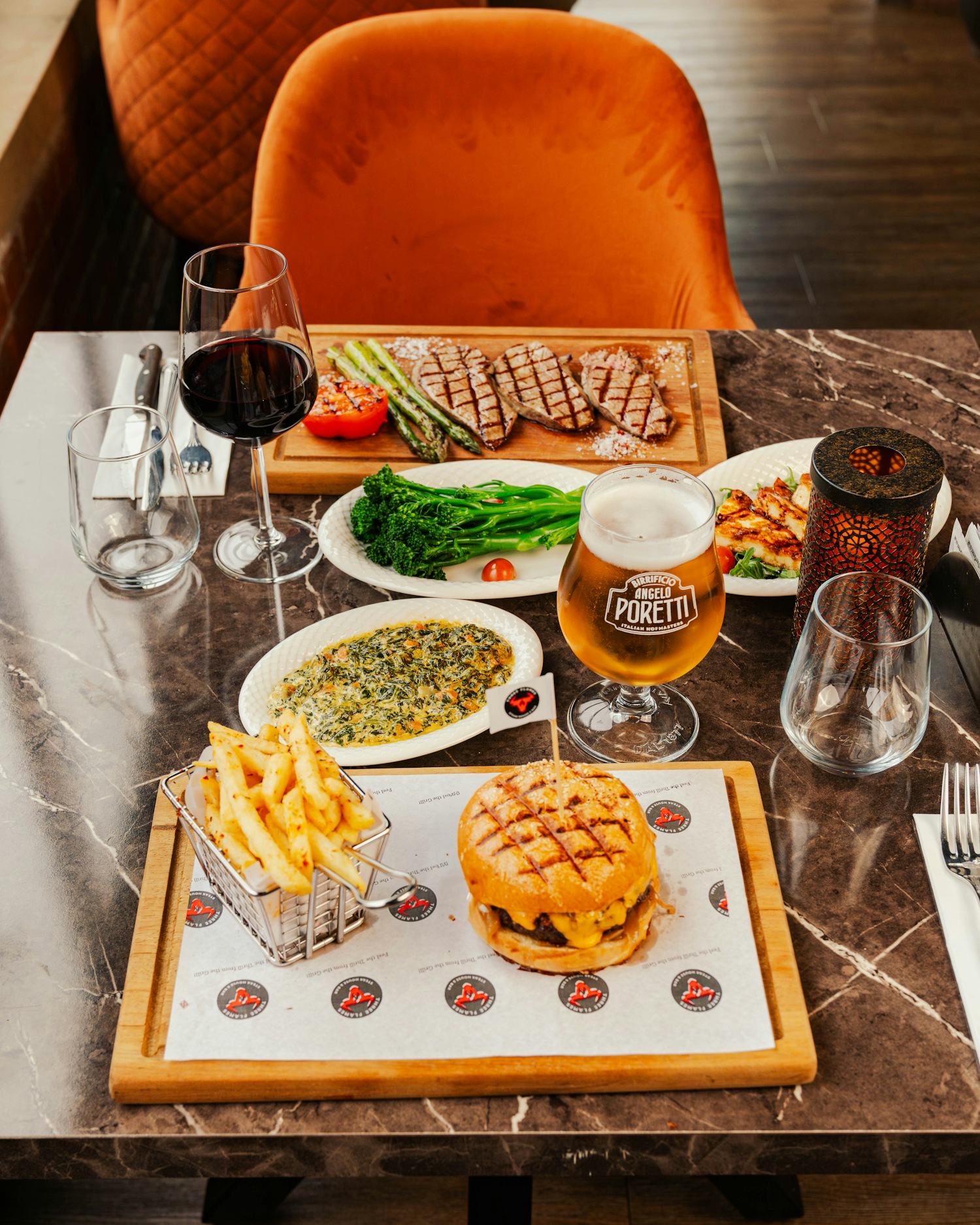 Table spread of steak, burger, sides and drinks